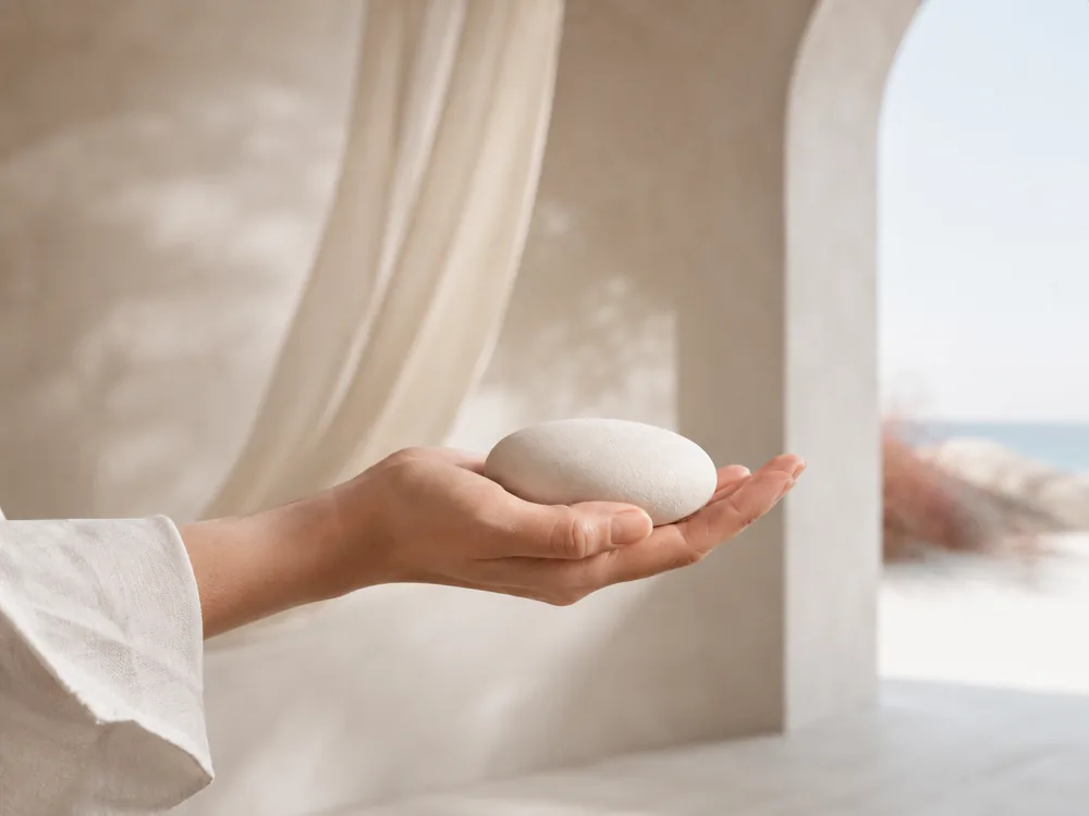 Een hand houdt een enkele steen vast